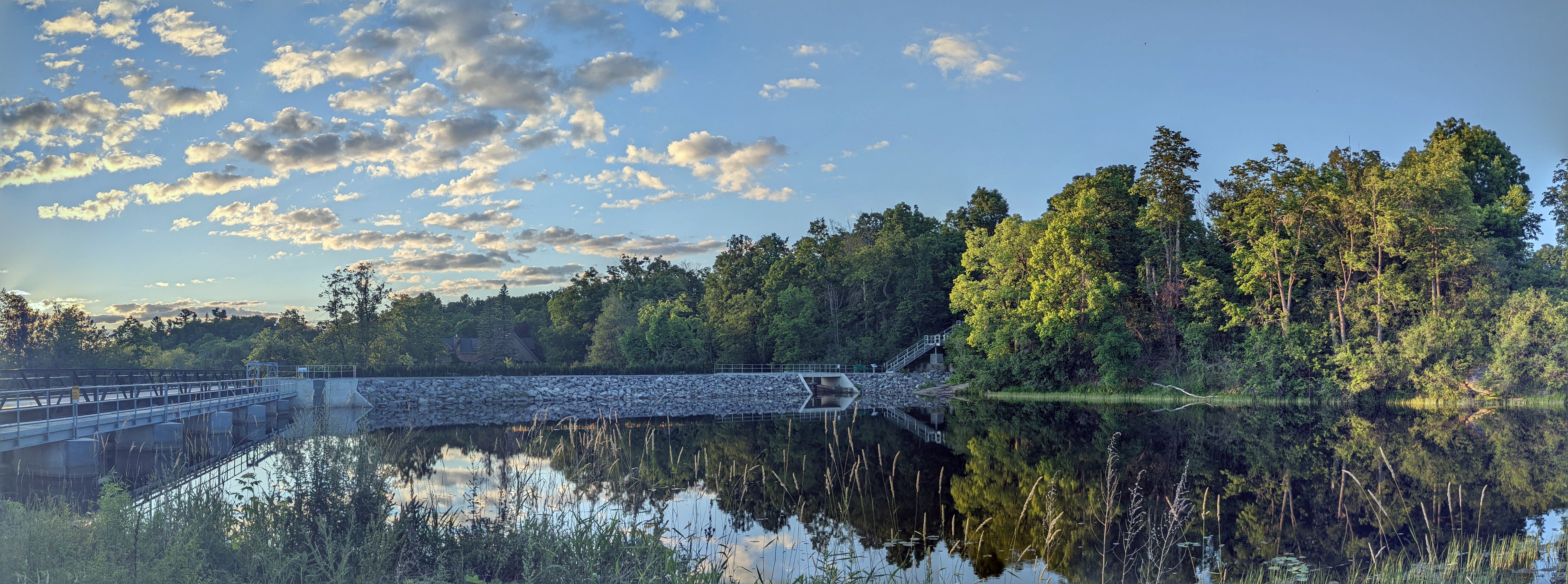 Wide shot of river with foliage and steel staircase